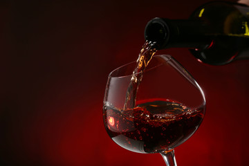 Red wine pouring into wine glass, close-up