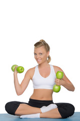 Happy woman with dumbbells of green apples