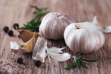 Raw garlic and spices on wooden table