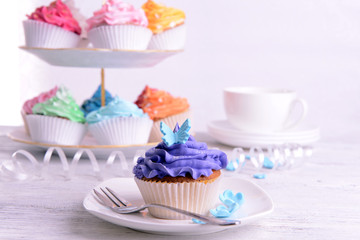 Delicious cupcakes on plate on table close-up