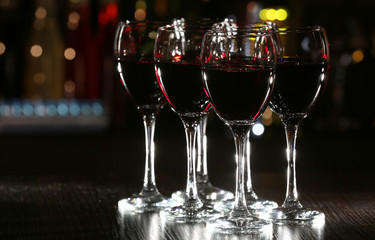 Glasses of wine with bar on background