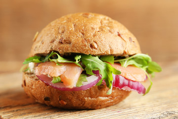 Sandwich with salmon on wooden background