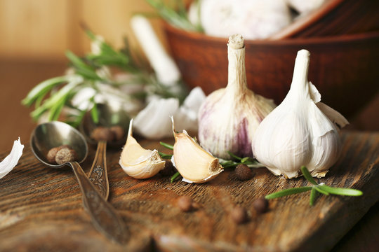Raw garlic and spices on wooden table