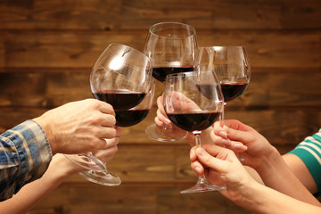 Clinking glasses of red wine in hands
