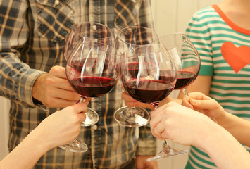 Clinking glasses of red wine in hands