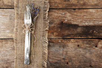 Silverware tied with rope burlap cloth and rustic wooden planks