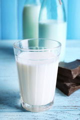 Glass and bottles of milk with chocolate chunks