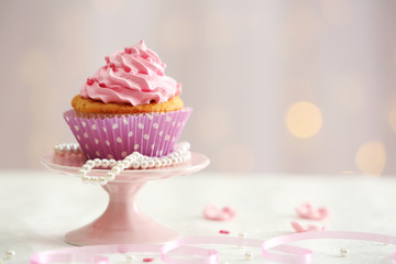 Sweet cupcake on table on light background
