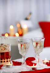 Champagne glasses and rose petals for celebrating Valentines