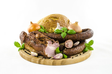 Bacon and sausage with vegetables and bread on wooden board