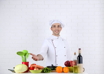 Chef at table with different products and utensil in kitchen