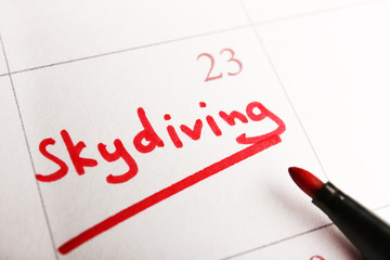Written plan Skydiving on calendar page background