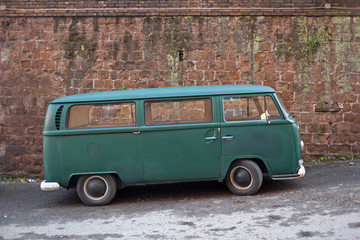 Green van parked near an ancient wall in Rome, Italy