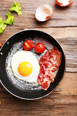Bacon and eggs on rustic wooden planks background