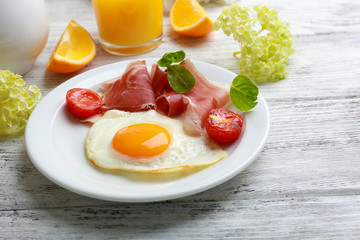 Bacon and eggs on color wooden table background.