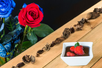 Chocolate pudding with strawberries and roses background