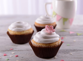 Delicious cupcakes on table on light background