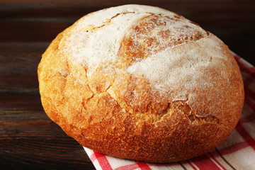 Fresh bread on napkin on wooden background