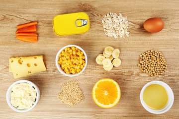 Various food products containing vitamins on wooden background