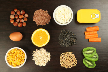 Various food products containing vitamins on wooden background