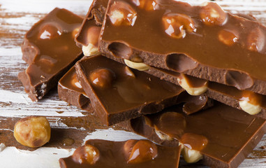 Chocolate bar with nuts on  wooden table