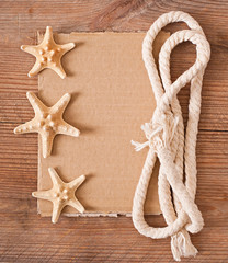Fototapeta na wymiar old paper, rope and starfish on old wooden background