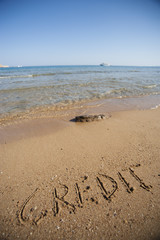 Word credit written in sand