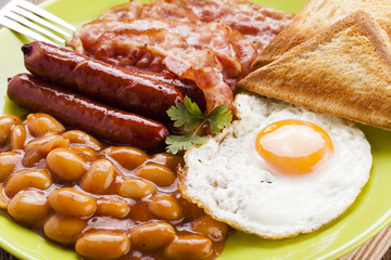 Full english breakfast with bacon, sausage, fried egg, baked bea