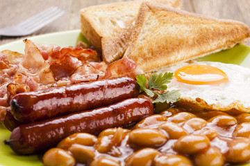 Full english breakfast with bacon, sausage, fried egg, baked bea