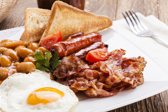 Full english breakfast with bacon, sausage, fried egg, baked bea
