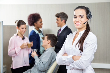 Obraz premium Smiling Female Customer Service Representative Standing Arms Cro