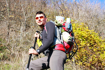 Naklejka premium Father is hiking with the 1.5 year baby in baby carrier