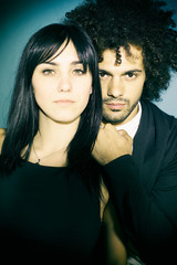 Cool fashionable couple posing in studio looking