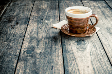 Obraz premium Coffee cup on old wooden table