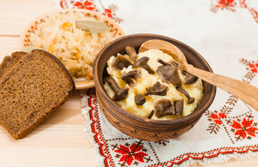 potatoes with mushrooms and sauerkraut on a wooden table, Lenten