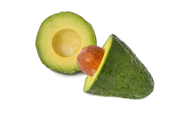 Green avocado cut in half with a bone