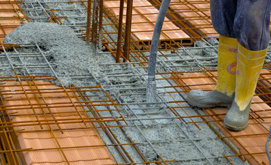 worker compacting cement in reinforcement form work
