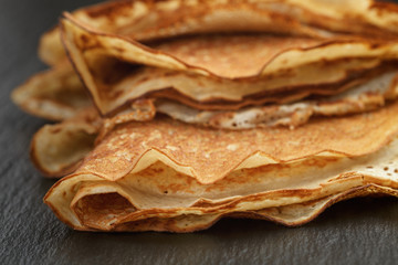thin crepes or blinis folded in triangles on slate board