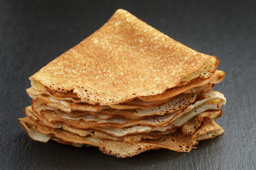 thin crepes or blinis folded in triangles on slate board