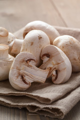 heap of fresh white mushrooms on sack cloth over table