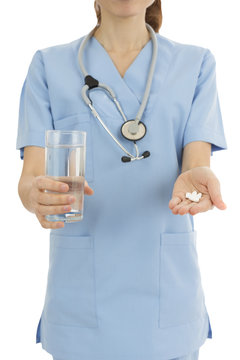 Nurse giving medicine together with a glass of water