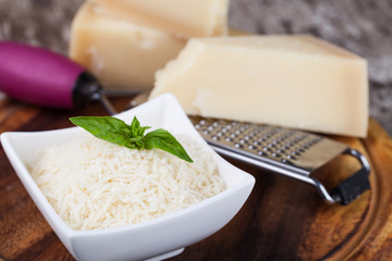 grated parmesan cheese and metal grater on wooden board
