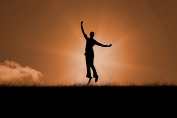 Composite image of silhouette of jumping woman