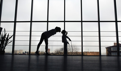 Fototapeta na wymiar Silhouette of mother and daughter in the gym.Kiss