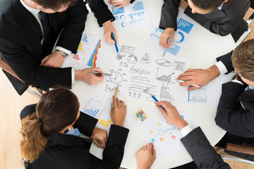 Group Of Businesspeople Analyzing Graph