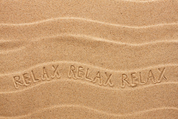 Relax inscription on the wavy sand