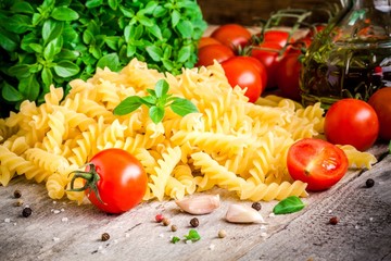 Ingredients for pasta: tomatoes, basil, fusilli, olive oil