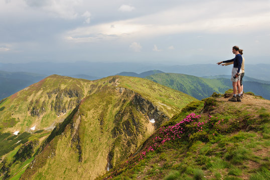 Trekker walking flowers field in mountain