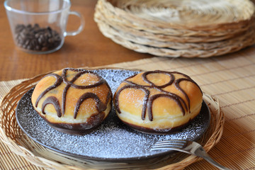 Traditional  doughnut with chocolate on the brown plate