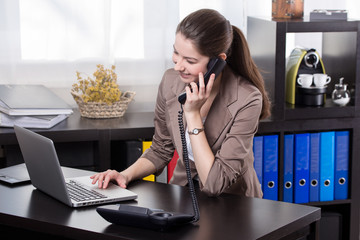 business woman with landline phone and notebook